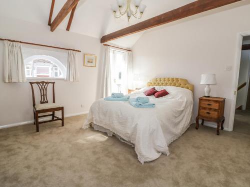 萨德伯里Stable Cottage的卧室配有床、椅子和窗户。