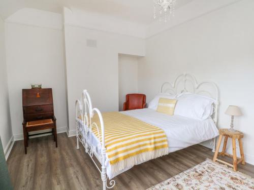 威勒尔Sunlight Soap Cottage的卧室配有白色的床,铺有木地板