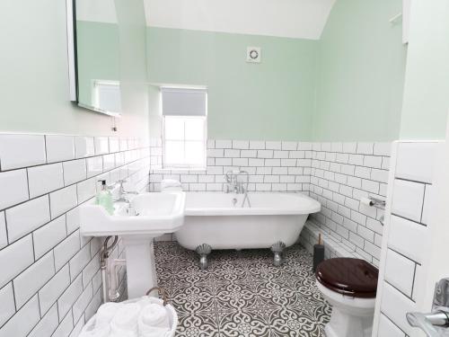 威勒尔Sunlight Soap Cottage的带浴缸、盥洗盆和卫生间的浴室