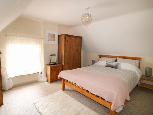 凯特林Manor Farm House Cottage的一间卧室设有一张大床和一个窗户。