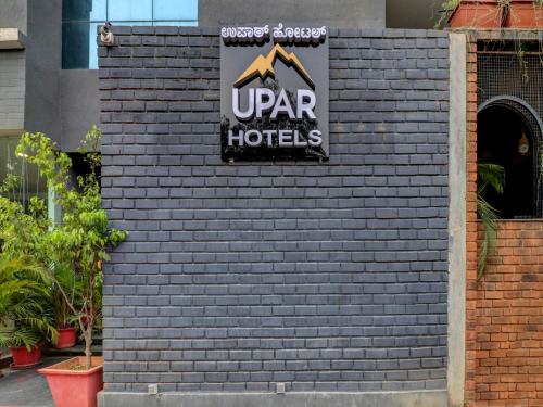 班加罗尔Upar Hotels Indiranagar的砖墙上的酒店标志
