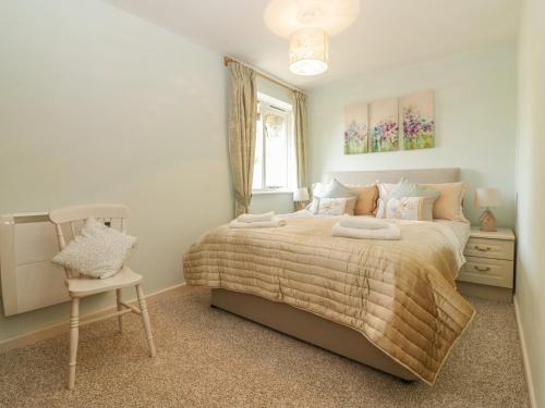 艾维布里奇Bearscombe的卧室配有床、椅子和窗户。