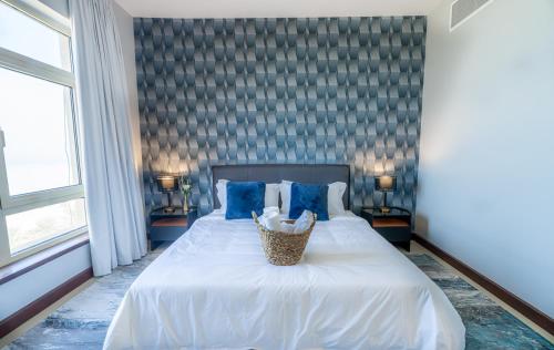 阿卜杜勒国王经济城Mabaat - Beach Tower - Building B - 251的卧室配有带蓝色枕头的大型白色床