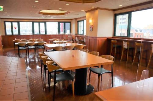 小松市Hyper Hotel Komatsu的餐厅内带桌椅的用餐室