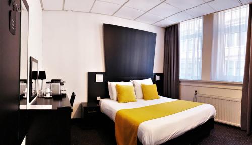 阿姆斯特丹德洛拉酒店的酒店客房配有一张带黄色枕头的大床