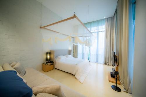 WangkataSala Khaoyai的白色卧室配有床和沙发