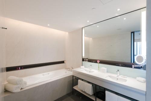 郑州郑州合盛怡思得酒店的带浴缸、水槽和镜子的浴室