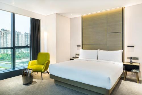 郑州郑州合盛怡思得酒店的一间卧室配有一张床、一张桌子和一把椅子