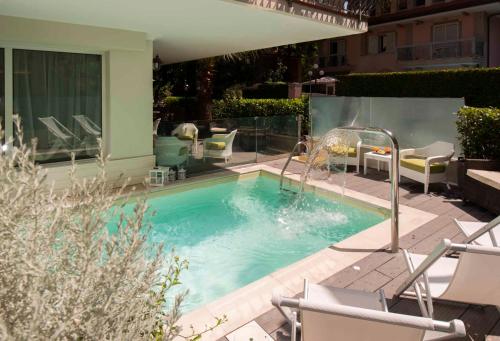 里乔内阿特拉斯酒店的一个带椅子和阴凉的小游泳池