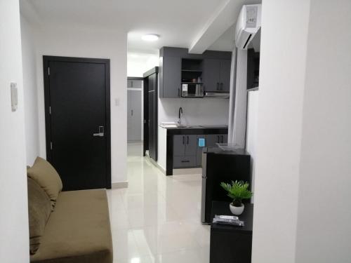 曼塔UMBRELLA SUITE的厨房设有黑色的门,铺有白色的地板。