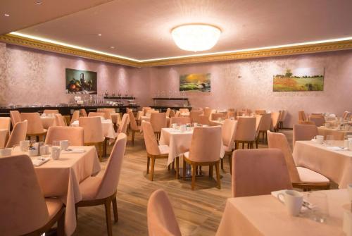 巴统巴统温德姆酒店的一间设有白色桌椅的用餐室