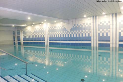 诺德奈Hotel Meeresburg的大楼内一个蓝色的大型游泳池