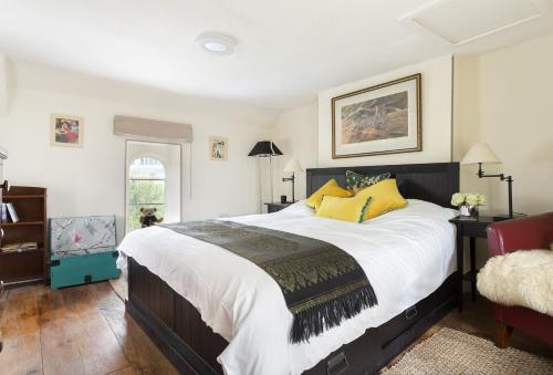 奇平诺顿Church Cottage的一间卧室配有一张带黄色枕头的大床