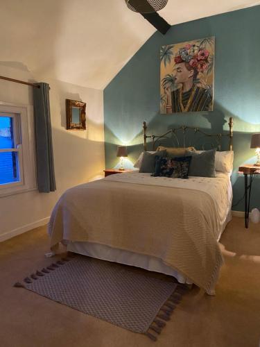 布由德利Mingo Cottage的卧室配有一张床,墙上挂有绘画作品