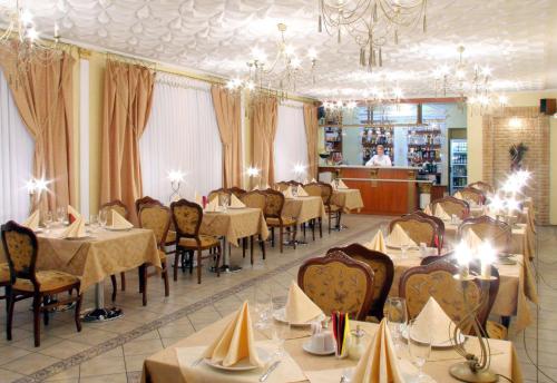 切尔尼戈夫Hotel Prydesnyansky的一间带桌椅和吊灯的餐厅