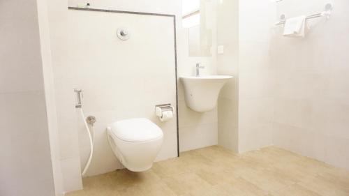 班加罗尔DayOne Suites的白色的浴室设有卫生间和水槽。