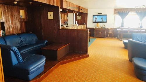 塞斯特雷Hotel Hermitage的一间带蓝色皮革家具的客厅和一间厨房