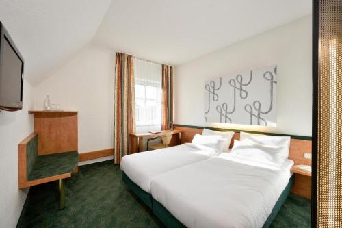 普海姆慕尼黑西部赛德尔会议酒店的酒店客房,配有床和电视