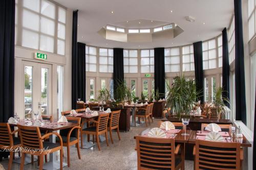 法尔肯堡法肯堡2000酒店的用餐室设有桌椅和窗户。