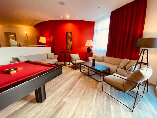 德累斯顿德累斯顿市多美洛酒店的客厅设有台球桌和红色墙壁