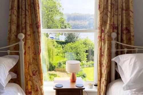 特鲁罗Riverside Idyll - the perfect Cornish Sanctuary的一间卧室设有两张床和窗户。