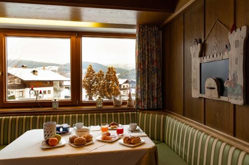 圣洛伦佐-迪塞巴托马丁内霍夫酒店的窗户房间里一张带食物盘的桌子