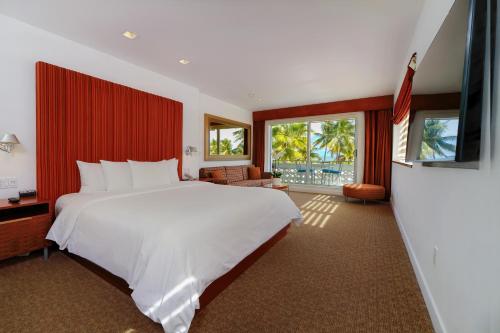 迈阿密海滩The Tony Hotel South Beach的卧室配有一张白色大床和红色墙壁