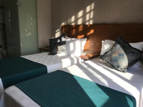 伊斯坦布尔GALATAHAN Hotel Istanbul Karakoy的一间卧室配有一张带绿色和白色床单及枕头的床。