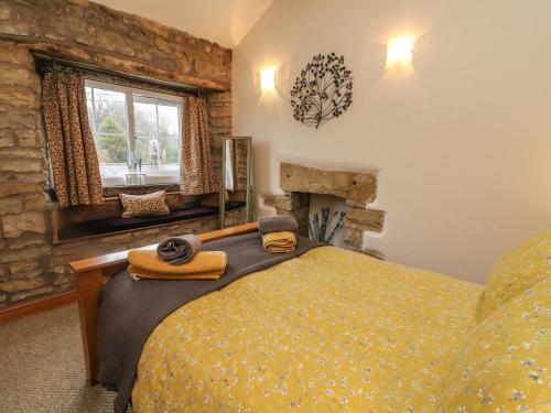 Burton in LonsdaleCobble Cottage的一间卧室设有一张床和石墙