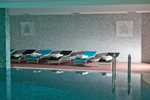 阿拉德Hotel Leon & Spa的一个带躺椅的游泳池和一个水游泳池
