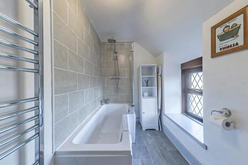 Cerrig-y-DruidionGwynfryn的带浴缸的浴室和窗户。