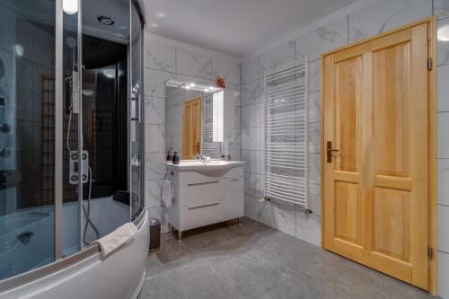 弗济内Apartman "Ela"的带淋浴、盥洗盆和浴缸的浴室