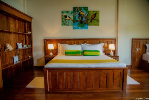 坦加拉Lagoon gate Tangalle Resort的一间卧室配有一张带两个绿色枕头的大木床