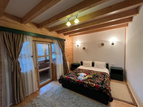 下维谢乌乡Pensiunea Iza的一间卧室设有一张床和一个窗口