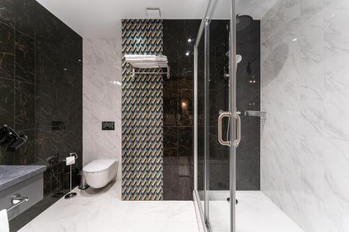 里加Old Riga Plaza Hotel的浴室设有玻璃淋浴间和卫生间
