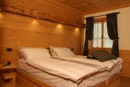 科尔蒂纳丹佩佐农场猎人之家旅馆的小木屋内一间卧室,配有一张床