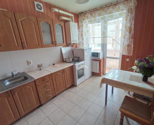 戈里亚奇克柳奇2х комнатная квартира на аллее сосен的厨房配有木制橱柜和白色冰箱。