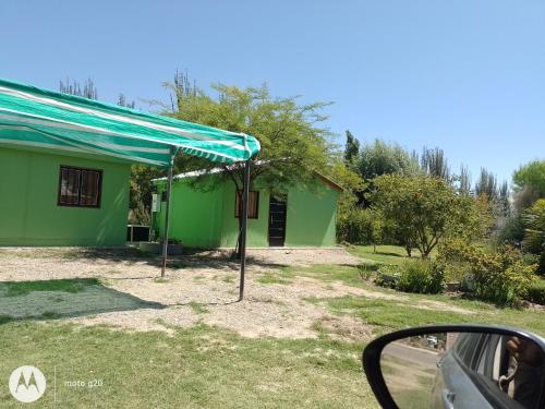 Colonia Las RosasHospedaje El TaTa的前面有蓝篷的绿色房子