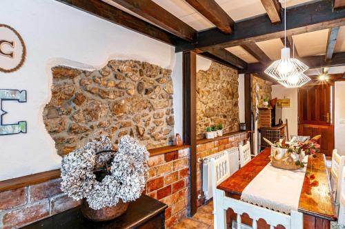 利亚内斯Casa Conce Zona de playa y montaña的厨房设有石墙和桌子