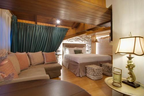 约阿尼纳ARCHONTARIKI Historic Boutique Hotel的一间卧室配有一张床和一个沙发