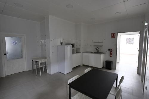 奥波里尼奥Casucho da Peregrina的白色的厨房配有桌子和冰箱