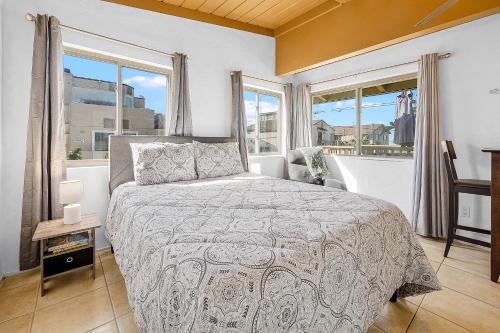 圣地亚哥甜美日落一室公寓的一间卧室设有一张床和两个窗户。