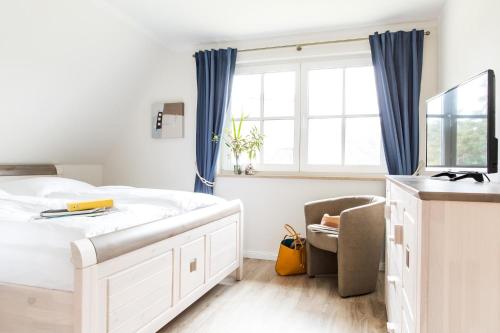 富伦多夫燕鸥10号度假屋的卧室设有一张白色大床和一扇窗户。