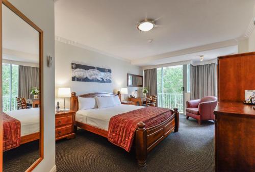 班达伯格Burnett Riverside Hotel的配有一张床和一把椅子的酒店客房