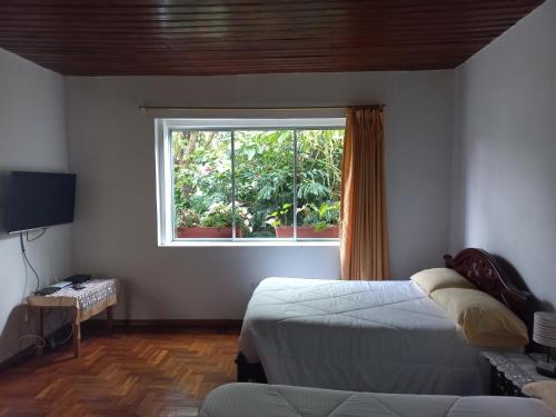 洛哈Villa Amada a place to relax and take a rest的一间卧室设有两张床和窗户。