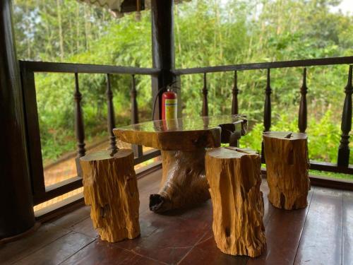 Gia NghĩaPhuong Nam Gia Trang Farmstay的门廊上的一张桌子和三张木头