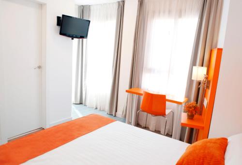 阿利坎特圣雷莫酒店的一间酒店客房,配有一张床和一台电视