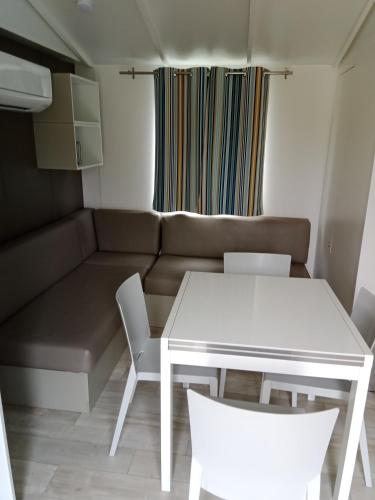 Saint-Aubin-le-CaufMobil home saint aubin的一间小客厅,配有白色的桌子和椅子