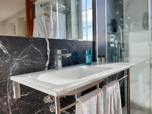 阿吉拉尔日波奥Hotel Marqués de Aguilar的浴室设有白色水槽和镜子