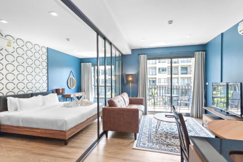 七岩Rain Cha Am - Hua Hin by J&P的一间拥有蓝色墙壁的卧室,配有一张床和一张桌子